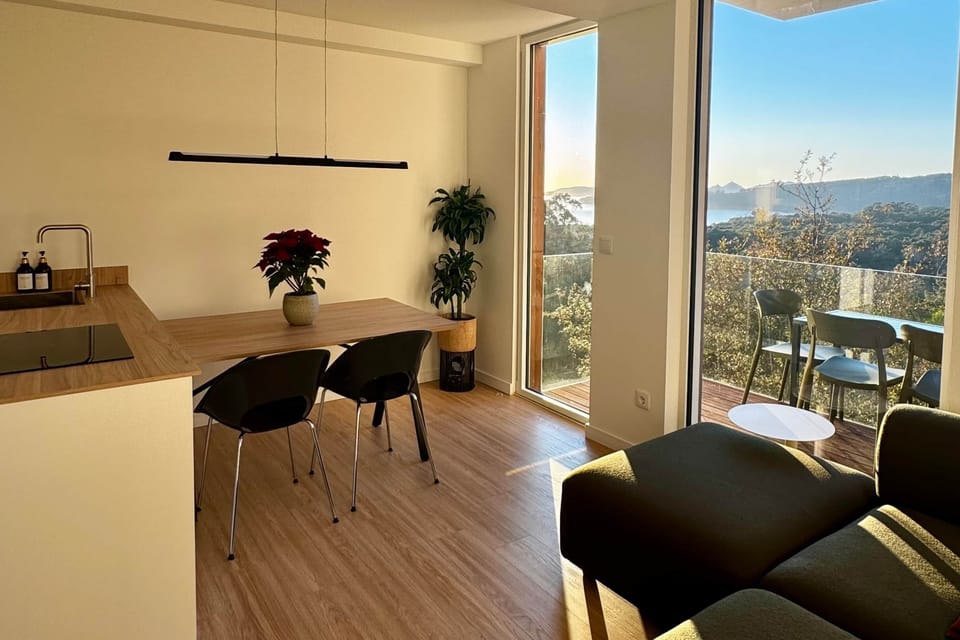 Light-filled open living space with private balcony and sweeping sea and mountain views.