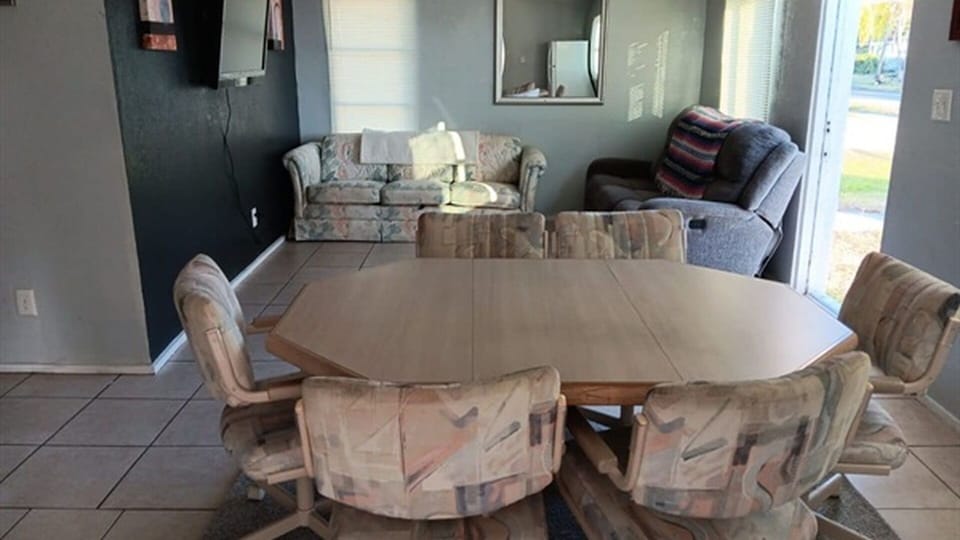 Living and dining area with sofa, recliner, and TV