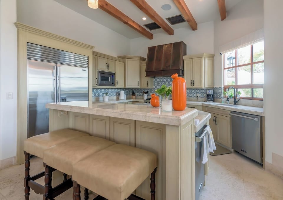 Spacious open-concept kitchen and dining area featuring a large island, bar seating, and seamless flow into the living space. Perfect for entertaining and enjoying a modern luxury villa experience.