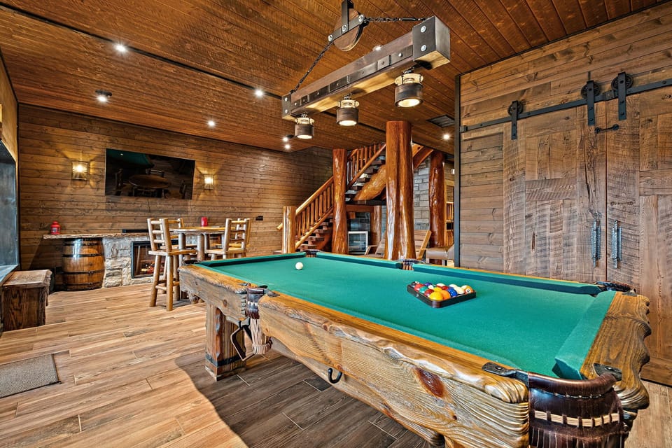 Beautiful log-cabin game room featuring a handcrafted pool table and cozy entertainment area for unforgettable nights in.