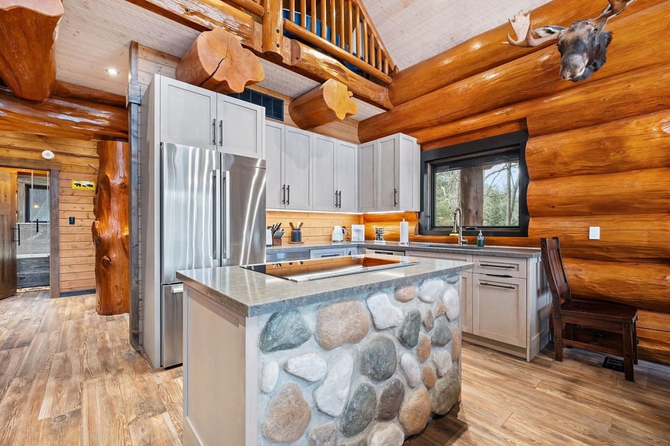 Modern chef’s kitchen with stainless-steel appliances, stone-faced island, and plenty of counter space for cooking.