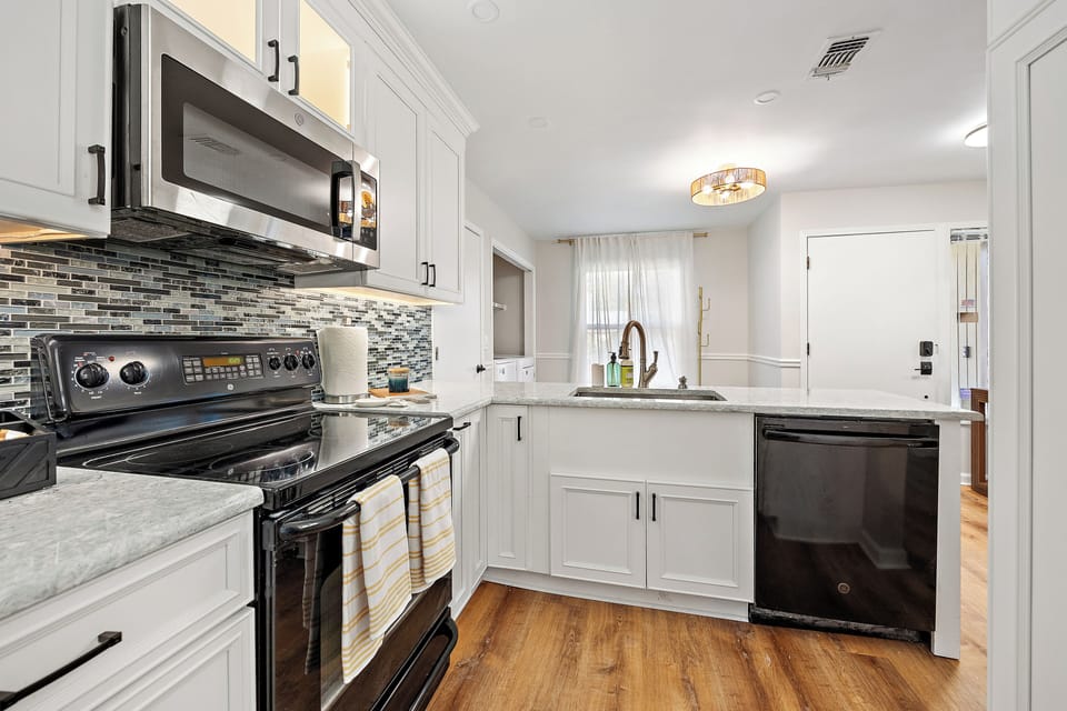 Full kitchen with electric stove, microwave and dishwasher