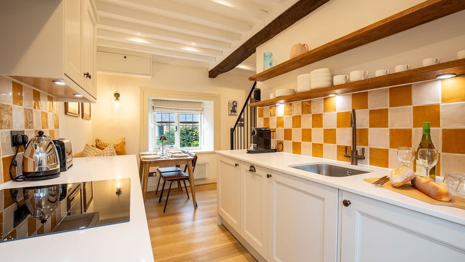 With splashes of mustard yellow in the tiling and soft furnishings the kitchen/diner has a colourful twist.
