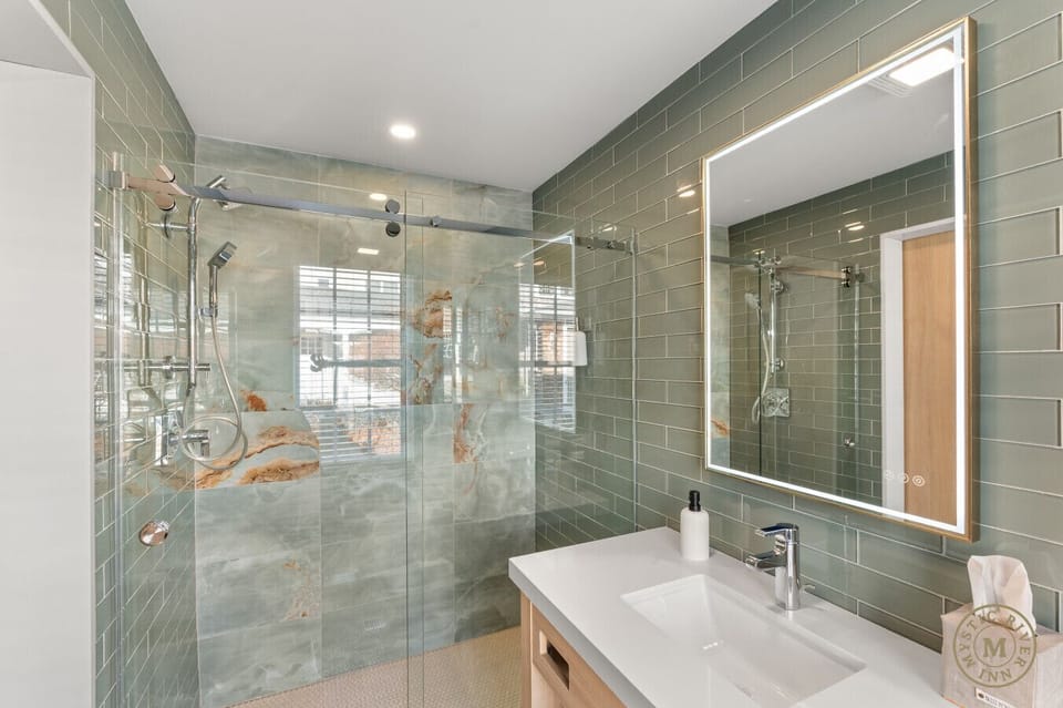 Sparkling clean full bathroom with a stocked with plush towels, shampoo, and body wash