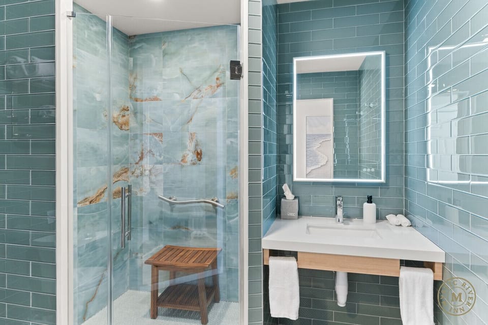 Sparkling clean full bathroom with a stocked with plush towels, shampoo, and body wash