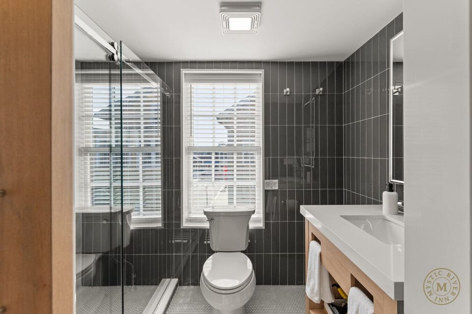 Sparkling clean full bathroom with a stocked with plush towels, shampoo, and body wash