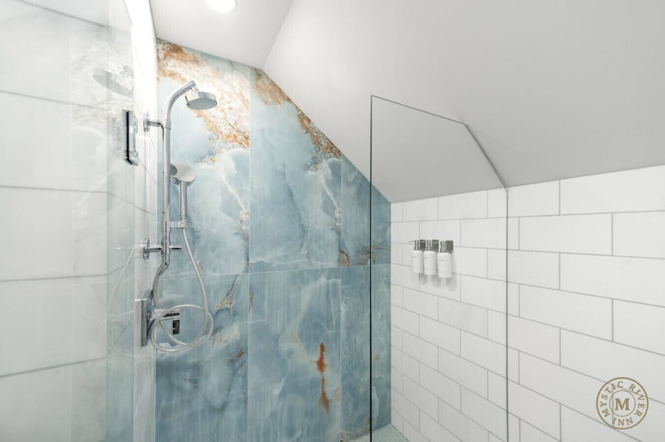 Sparkling clean full bathroom with a shower/tub combo, stocked with plush towels, shampoo, and body wash