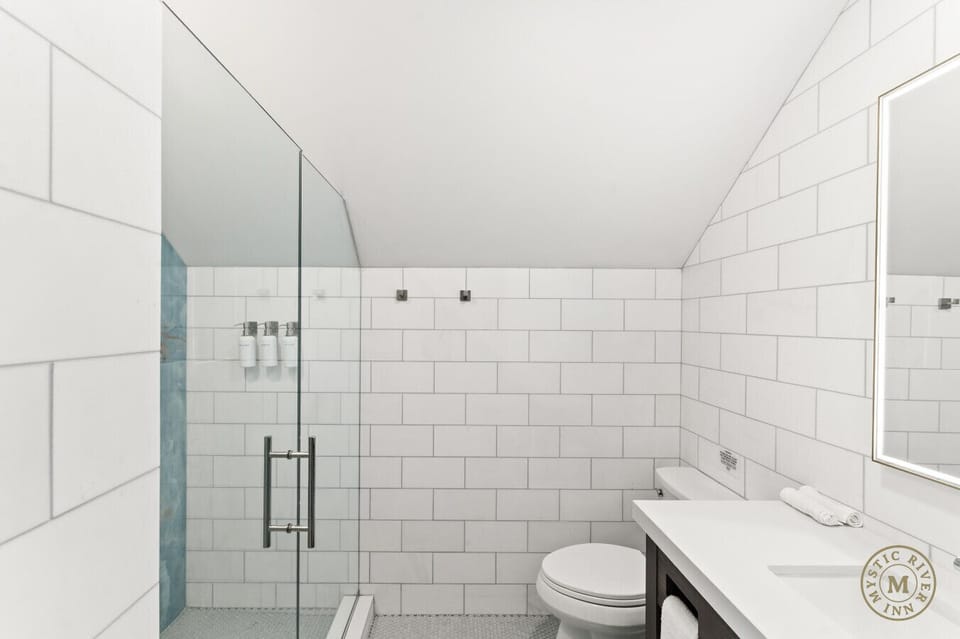 Sparkling clean full bathroom with a shower/tub combo, stocked with plush towels, shampoo, and body wash