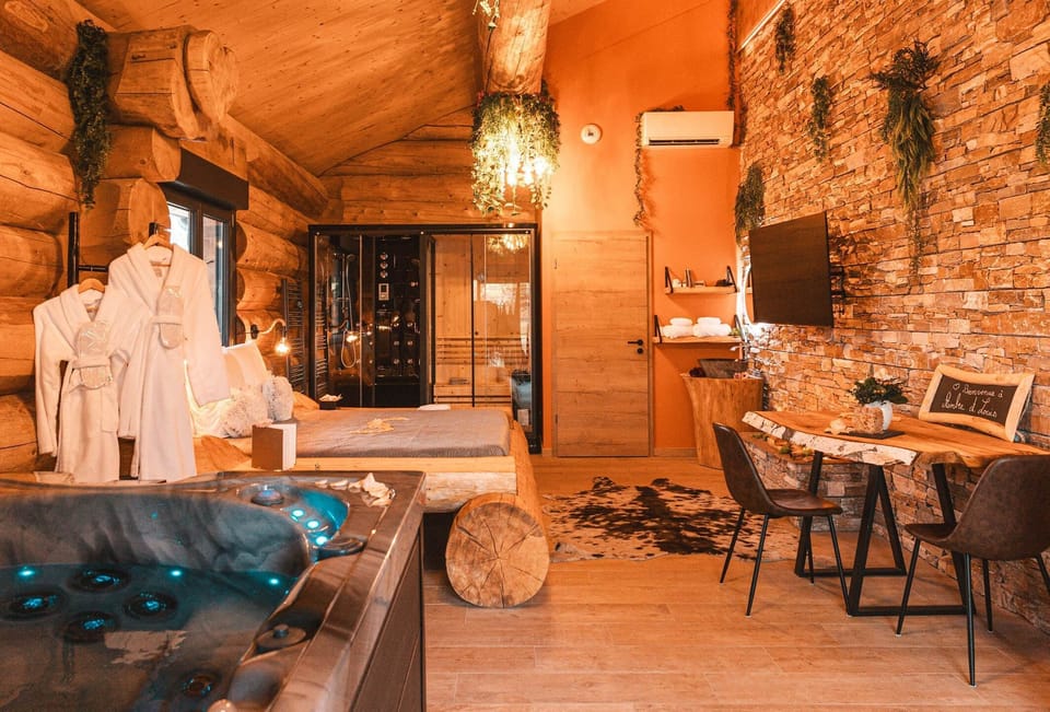 Pièce de vie cosy en fustes – pierre, bois et cheminée vapeur