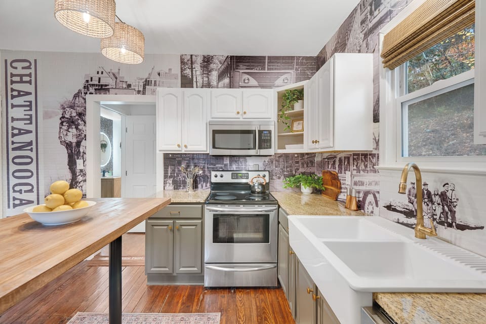 Full kitchen with a farmhouse sink and stainless steel appliances.