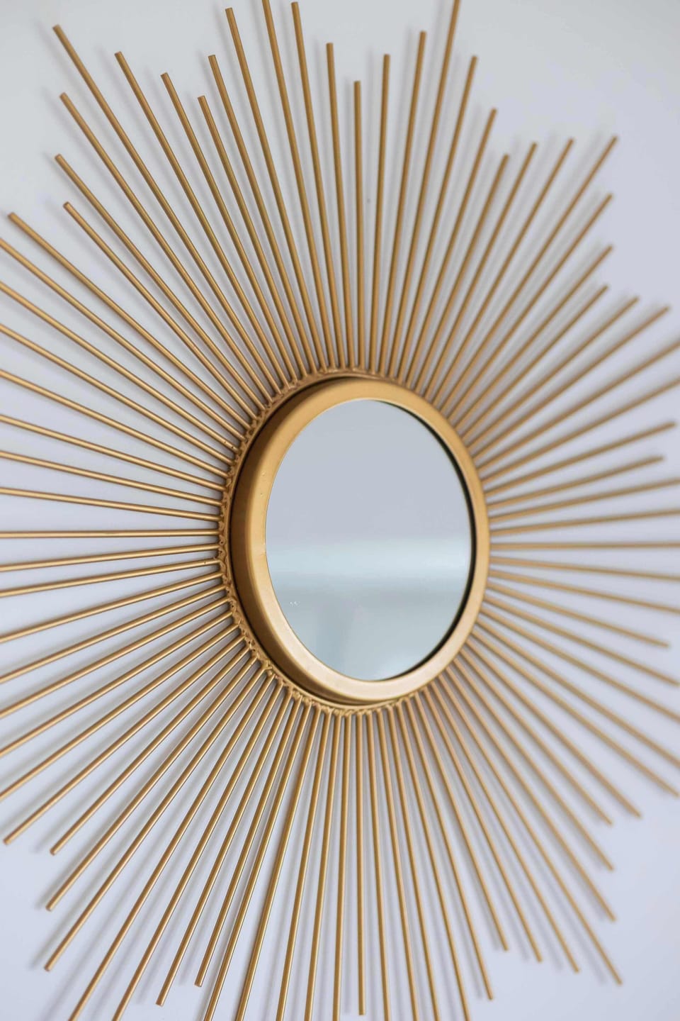 The decorative mirror in a golden frame adds a touch of elegance and reflects light, making the space brighter and more welcoming.