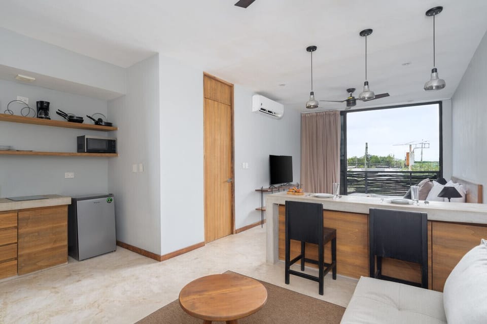 Stylish studio with comfy living area, dining island, and tropical views.