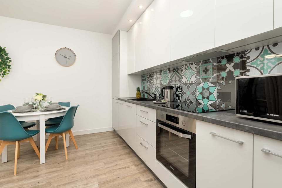 A spacious view of the kitchen with a comfortable table invites guests to enjoy relaxed breakfasts and shared moments over meals.