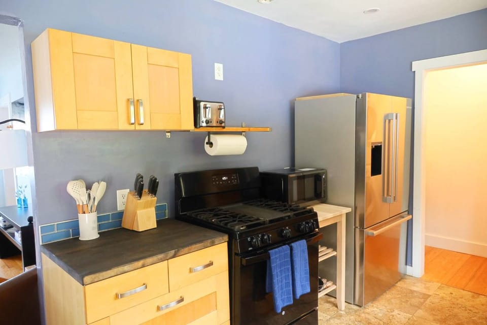 Enjoy a bright, welcoming kitchen with warm wooden cabinets and fully equipped with all the essentials, perfect for preparing anything from a quick breakfast to a home cooked meal during your stay.