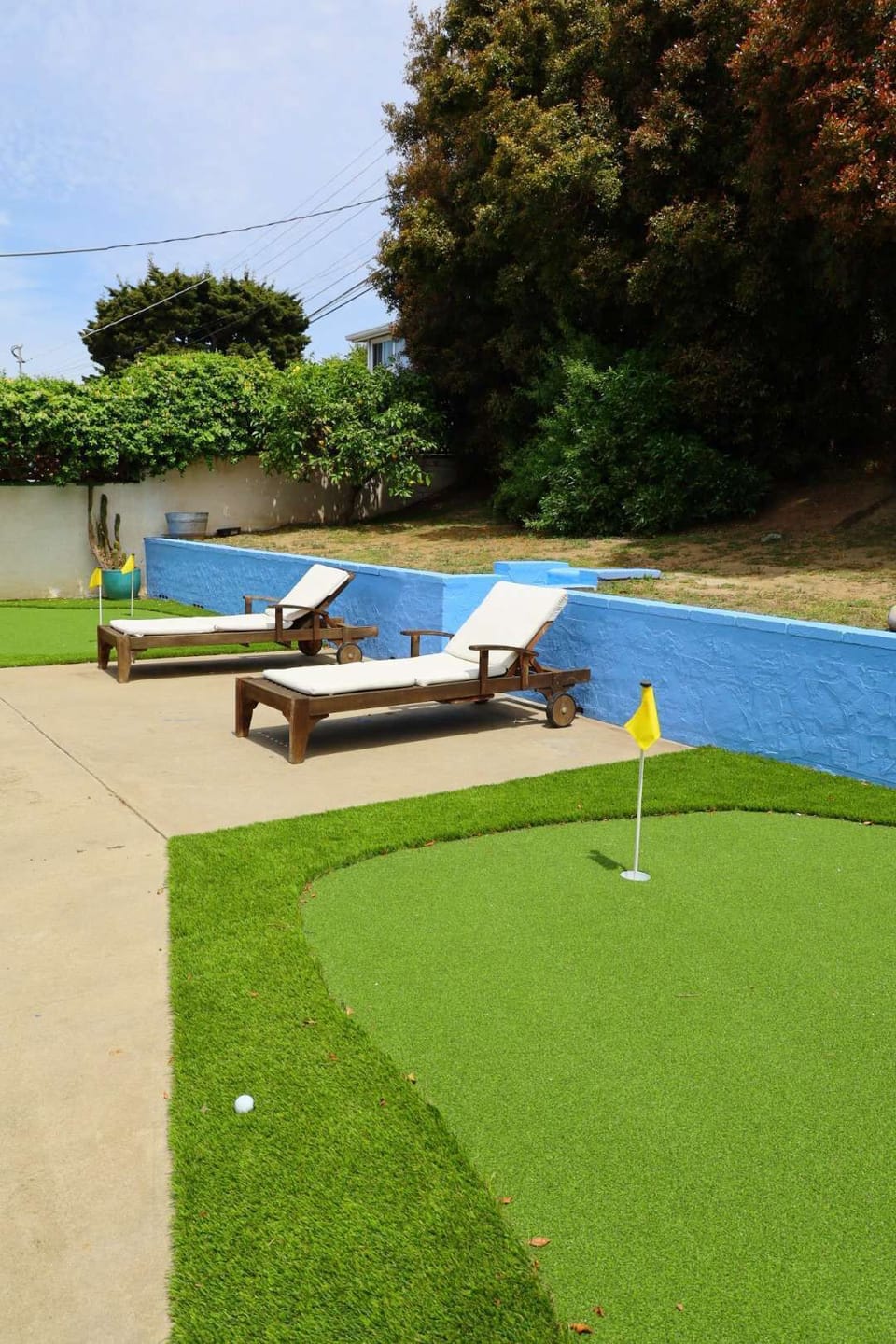 A spacious backyard with a small putting green, lounge chairs for relaxing and for great entertainment. 