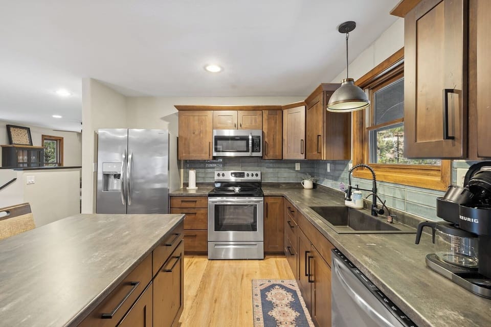 Modern, well-equipped kitchen with stainless steel appliances, granite counters, and a spacious center island. Perfect for quick meals or gourmet cooking!