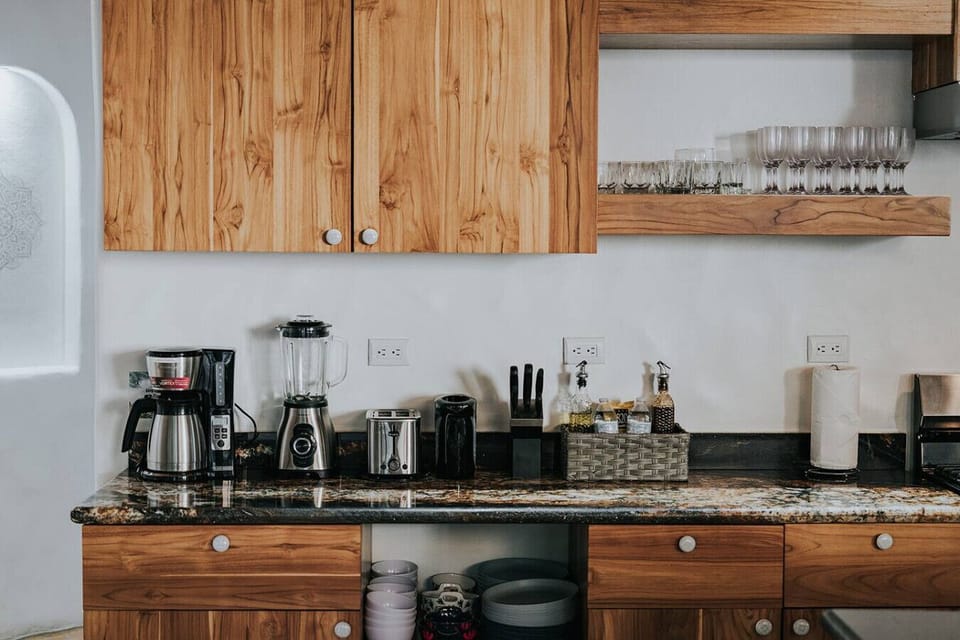 This kitchen is stocked for real cooking, with quality appliances, spices, and all the essentials organized against warm wooden cabinetry. It feels practical, welcoming, and ready for anything from morning coffee to full meals.