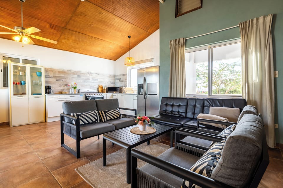 Bright open-plan living room and kitchen with comfy seating and equipped kitchen