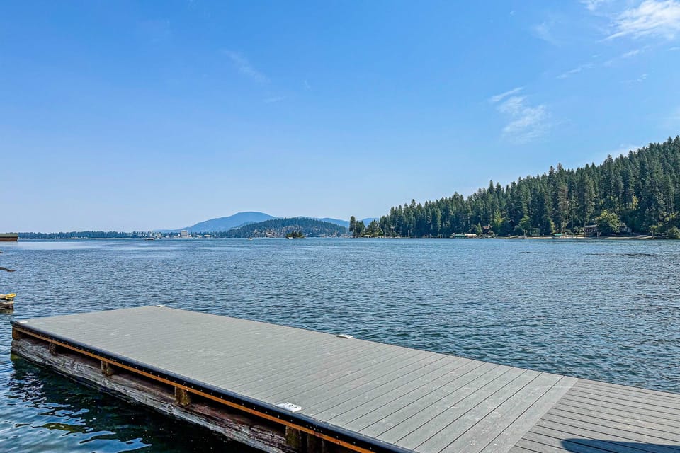 Sunny floating dock platform with wide-open lake and mountain panorama — the view that makes checkout feel impossible