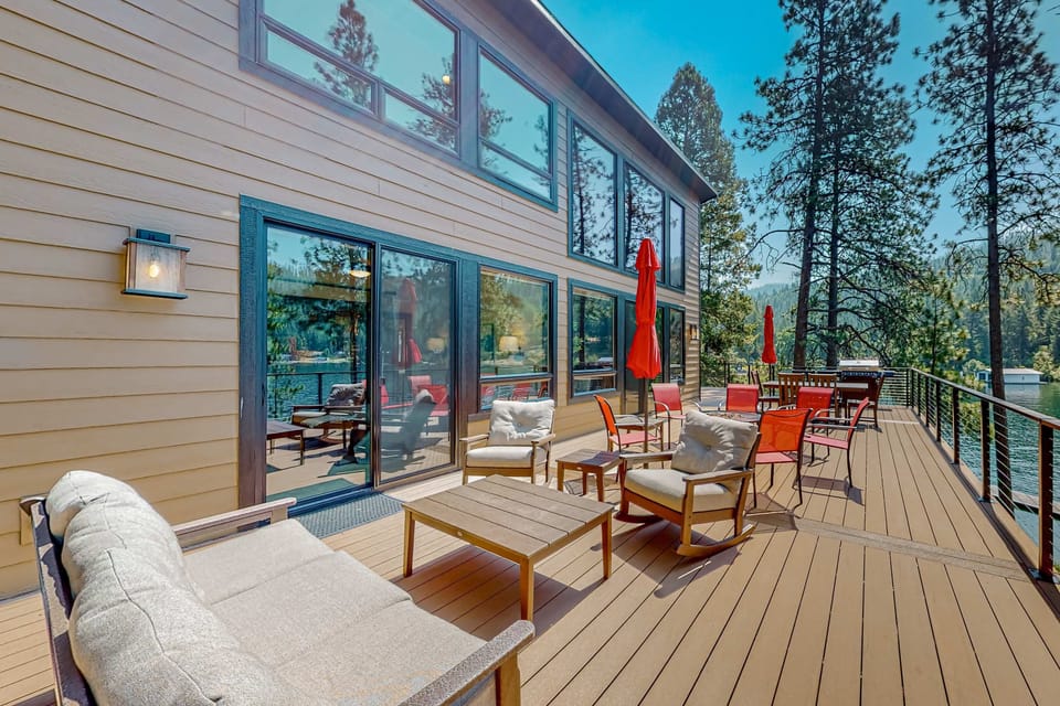 Spacious upper deck with sofa, rocking chairs, dining set, and sliding door access to the great room lakeside