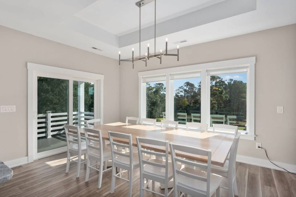 Sunlit dining area w/ large table, ideal for shared meals & long conversations.