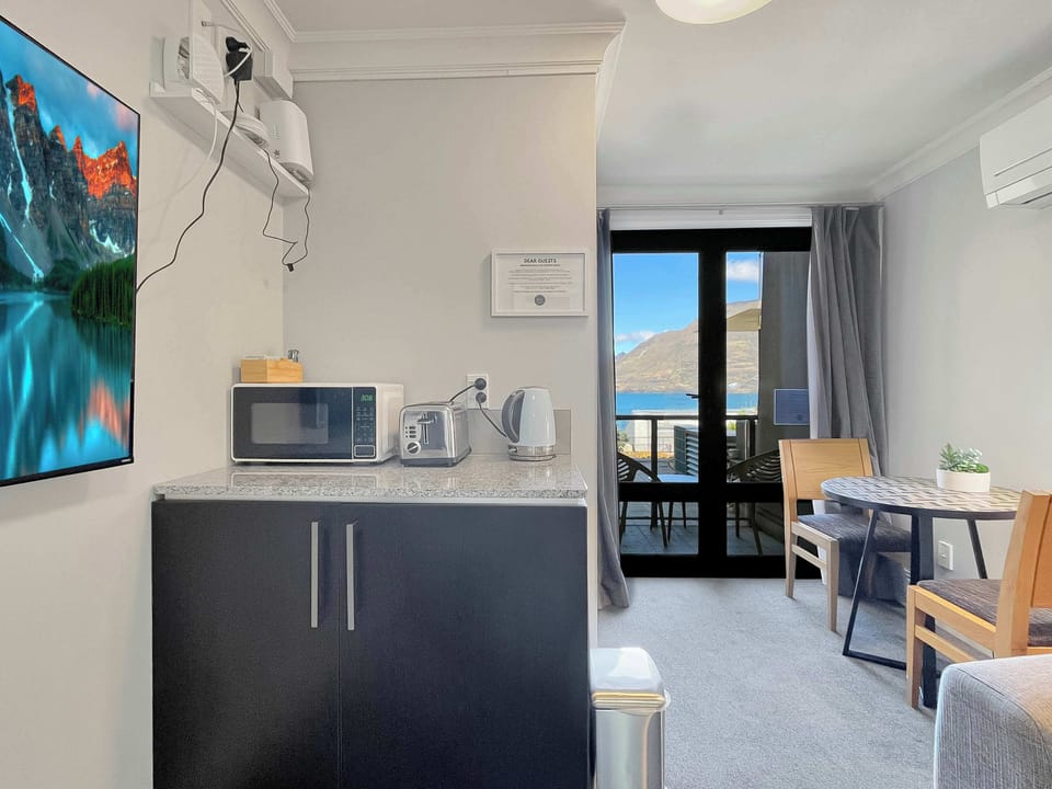 Well-equipped kitchenette with dining space, opening through to the balcony and lake views.