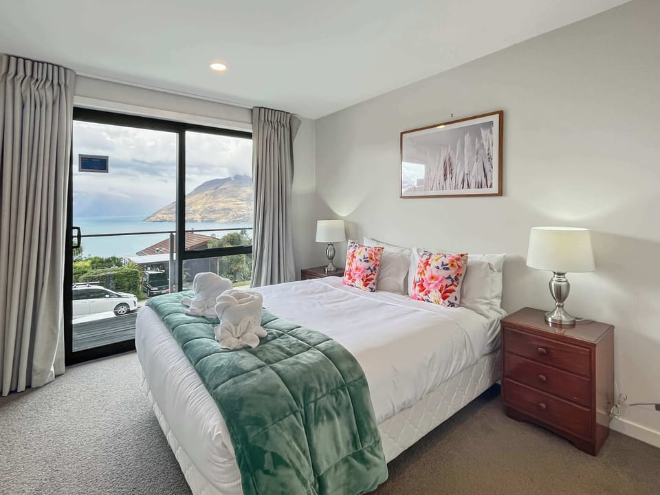 Bright bedroom with a king bed and wide lake and mountain outlook, ideal for unwinding between adventures