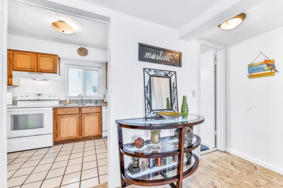A welcoming entryway leads into a bright kitchen, perfect for easy meals during your beach stay. Coastal décor and natural light create a warm, inviting start to your seaside getaway.