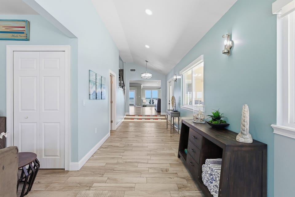 Welcoming beach stay entryway with coastal tones, stylish accents, and a bright open feel. This spacious hallway leads toward ocean views, creating a relaxing first impression for your seaside getaway.