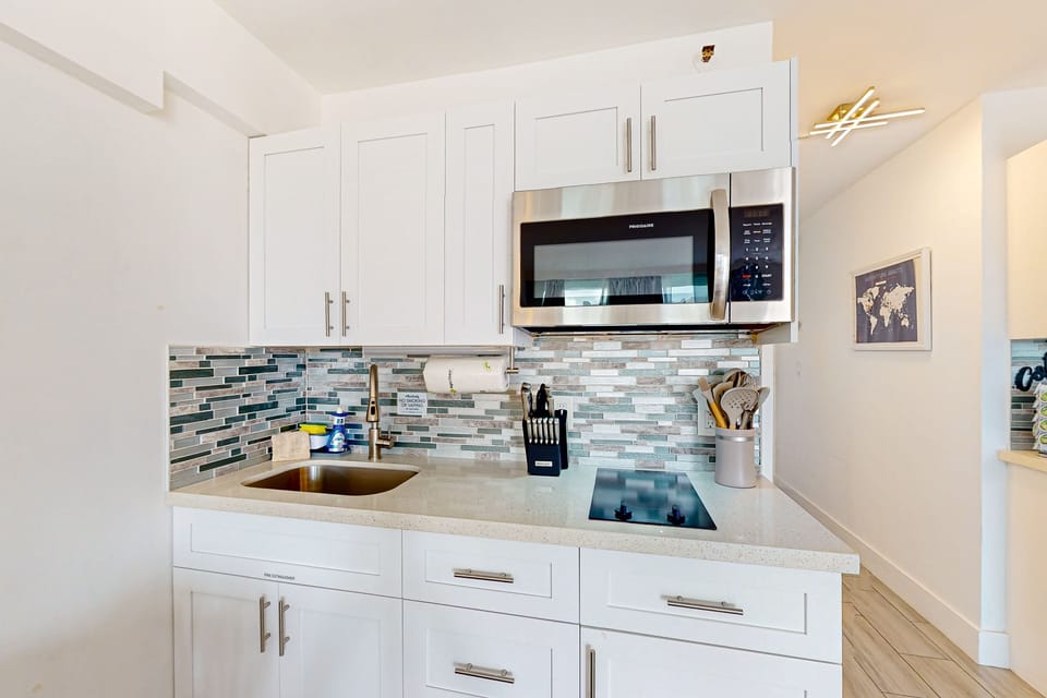Bright, modern kitchenette with sleek appliances, perfect for prepping meals during your beach stay. Clean design and coastal-inspired backsplash make this a relaxing oceanside retreat.