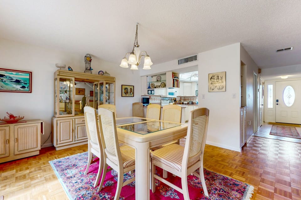 Gather and dine comfortably during your beach stay in this bright coastal dining area. With seating for the whole group and easy access to the kitchen, it's perfect for shared meals after a fun day at the beach.