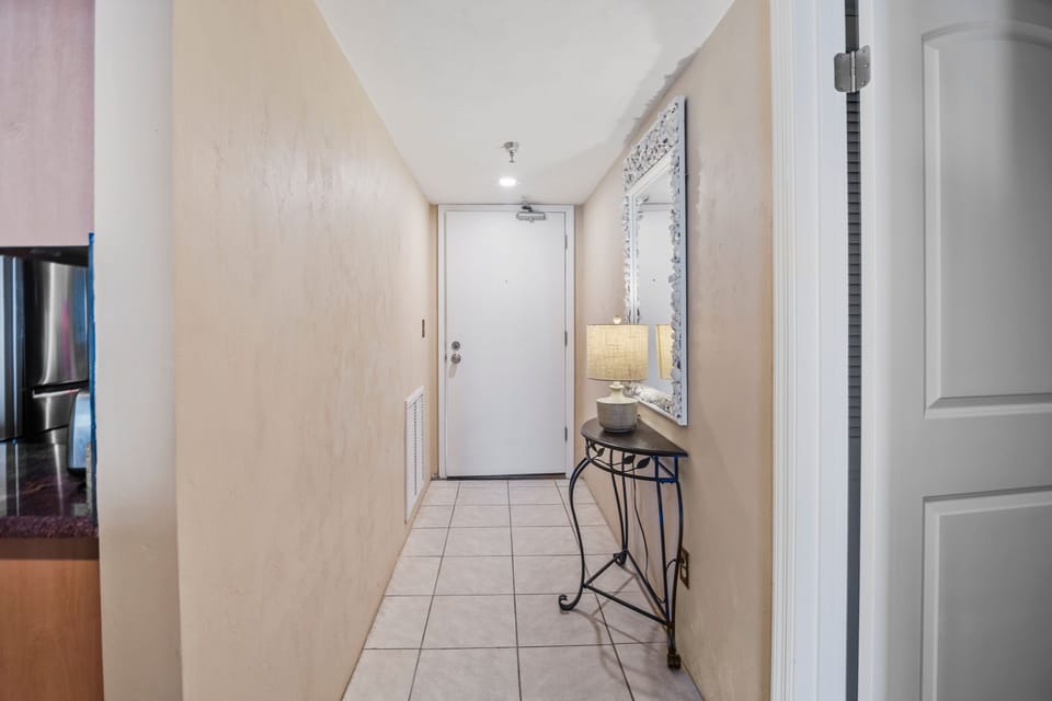 Bright and inviting entryway with coastal touches, tiled flooring, and convenient layout. A warm welcome to your relaxing beach stay, setting the tone for comfort, convenience, and seaside relaxation from the moment you arrive.