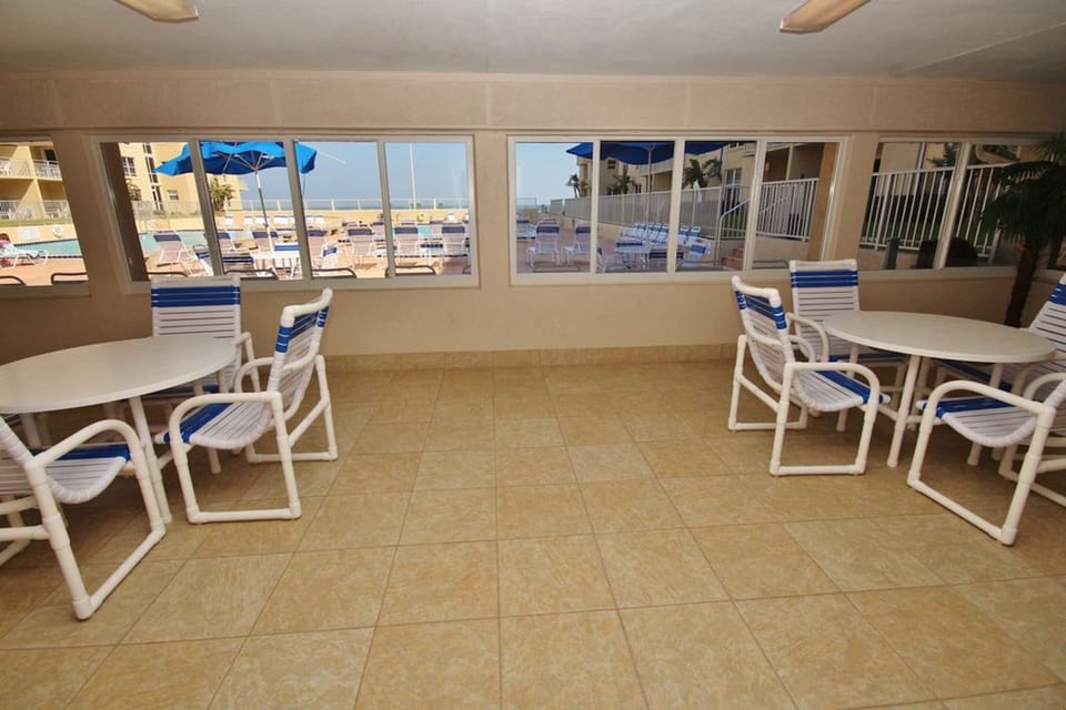 Take a break during your beach stay in this shaded poolside seating area, perfect for enjoying ocean breezes, casual meals, or relaxing between swims just steps from the beach and resort pool.