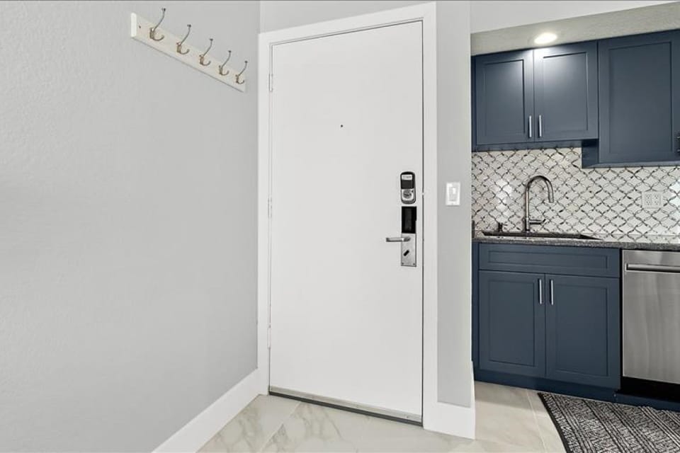 Step into a clean, modern entryway designed for an easy beach stay. Featuring a secure entry, convenient hooks, and coastal finishes, it's the perfect welcome after a fun day at the beach.