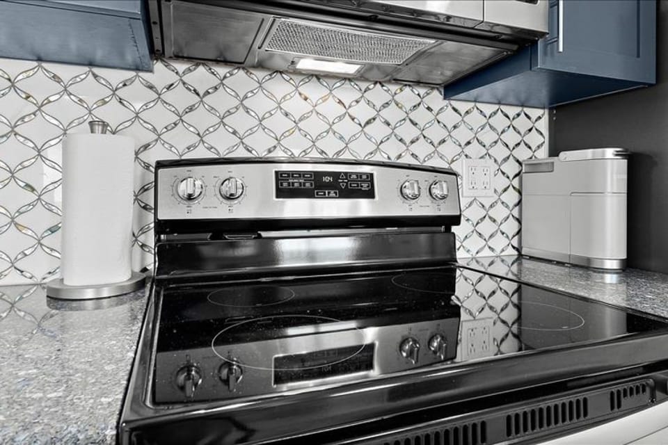 Enjoy the convenience of modern kitchen appliances during your beach stay. This sleek cooktop and stylish backsplash make preparing meals simple, so you can spend more time relaxing by the ocean.