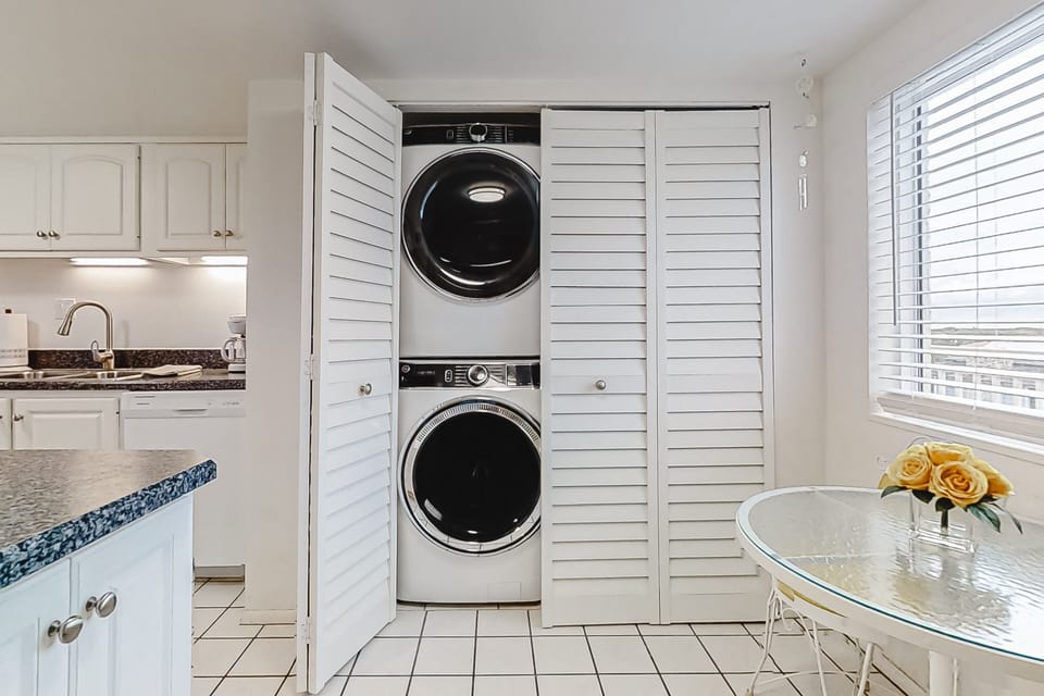 Enjoy the convenience of an in-unit washer and dryer, perfectly located near the kitchen—ideal for refreshing beach towels and keeping everything clean and ready during your comfortable beachfront vacation stay.