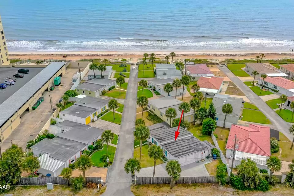 Get a bird's-eye view of this charming beach stay, perfectly located just steps from the shoreline. Surrounded by palm trees and coastal cottages, this vacation rental offers unbeatable proximity to the beach and ocean breezes.