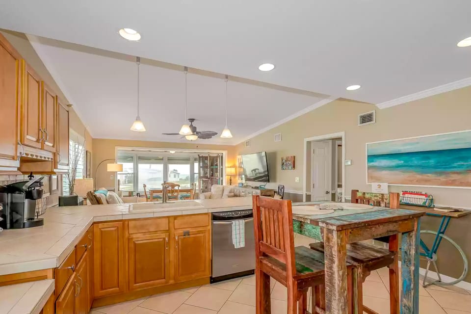 Airy open-concept kitchen flowing into the living area, perfect for gathering after a day at the beach. Enjoy coastal décor, modern comforts, and a relaxed layout ideal for an unforgettable beach stay.