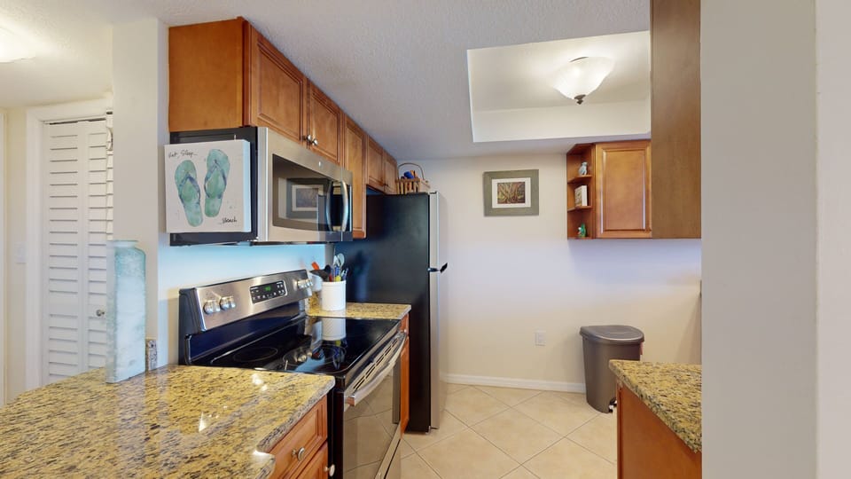 Coastal-inspired kitchen with granite counters and modern appliances—perfect for cooking during your beach stay. Enjoy a bright, welcoming space just steps from the shore.
