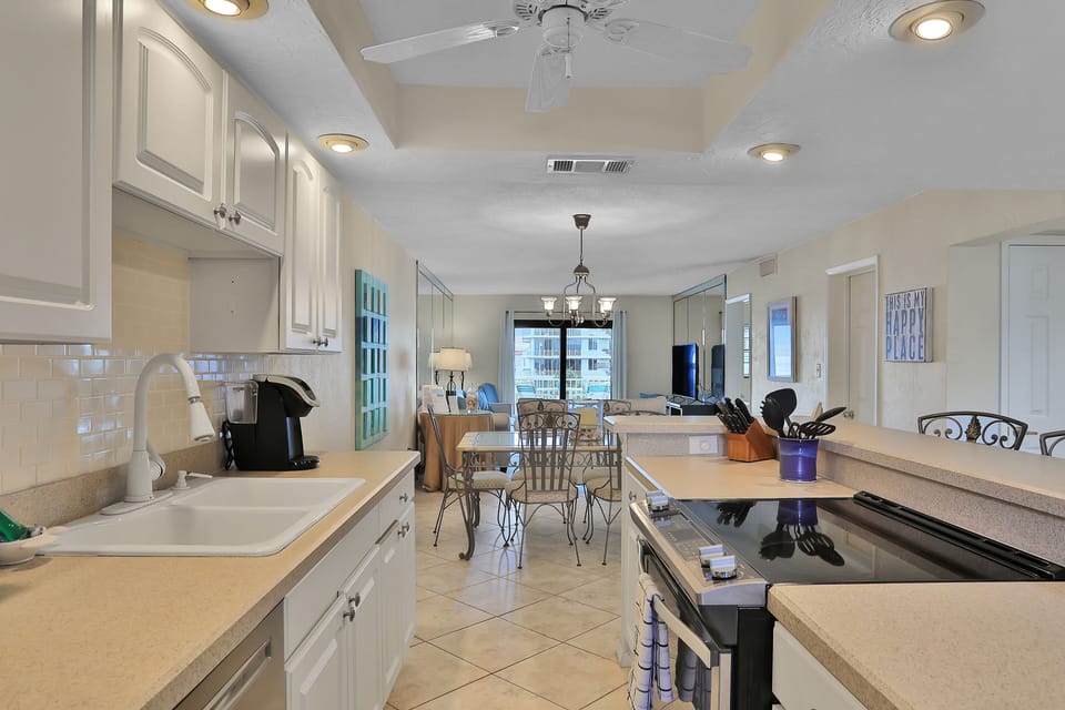 Enjoy a spacious, fully equipped kitchen with ample counter space and open sightlines to the dining and living areas. Perfect for cooking, gathering, and relaxing together during your beach stay.