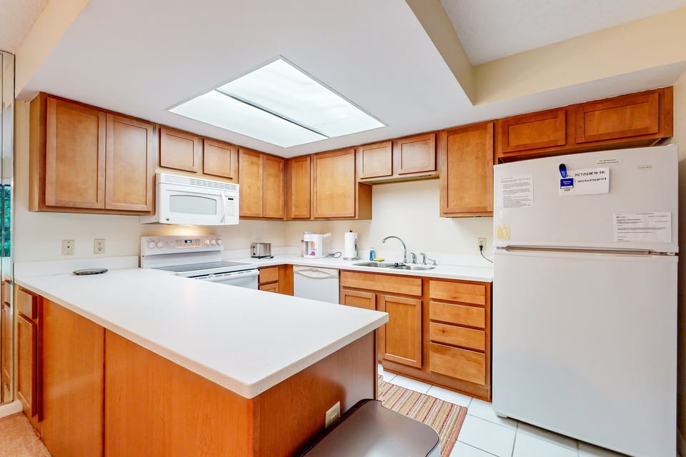 This spacious kitchen features ample counter space and full appliances, making meals easy during your beach stay. Enjoy the convenience of home while relaxing on your coastal getaway just minutes from the beach.