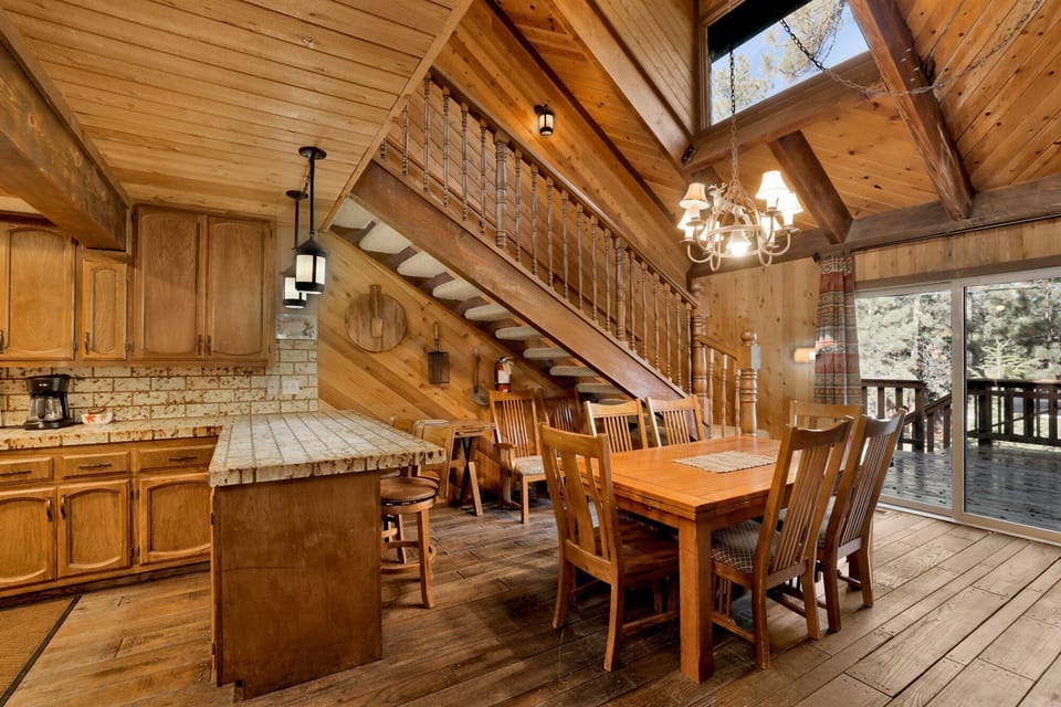 Kitchen with a refrigerator, stove, microwave, oven, toaster, coffee machine, dishwasher, and a dining table to enjoy a delicious meal.