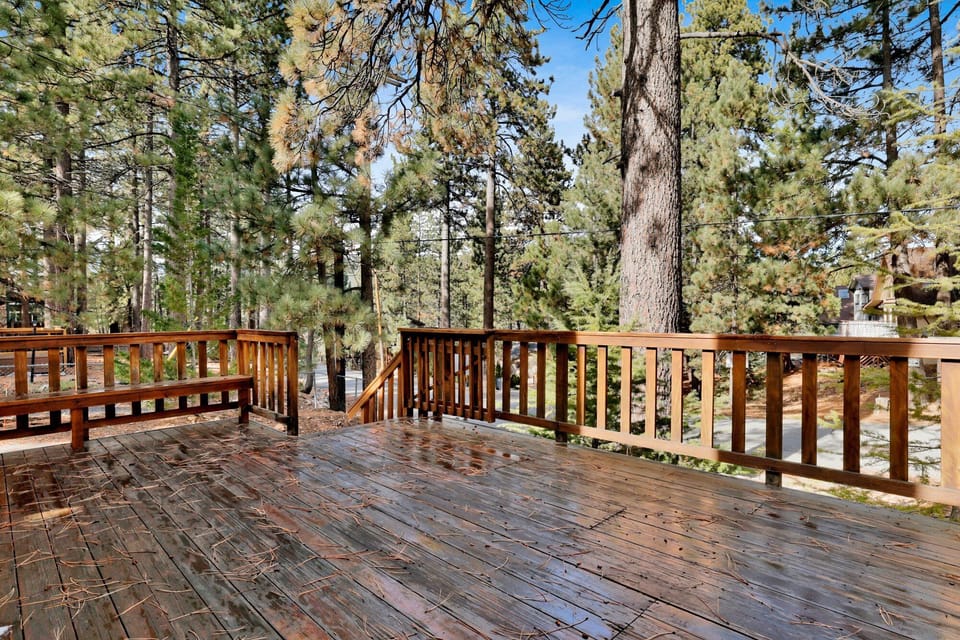 Welcoming cabin entry surrounded by towering pine trees, offering fresh mountain air and a peaceful forest setting—the perfect first impression for your Big Bear Lake getaway.