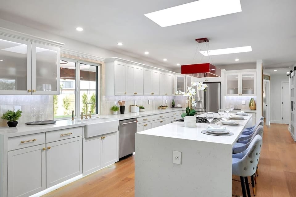 Fully equipped kitchen with stainless steal appliances, LED lighting, and a kitchen island with bar seating for 4 guests.