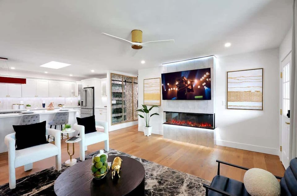 Open living area featuring a smart TV, plush furnishings, and a fireplace.