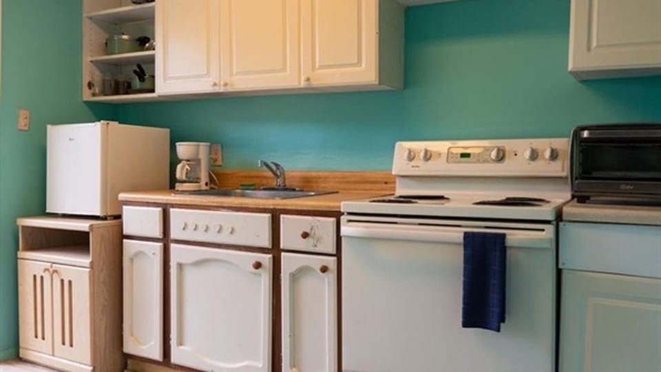Kitchen with full-size stove, sink, coffee maker, and toaster oven