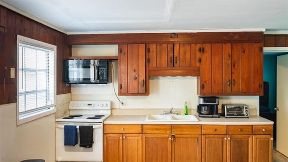 Main kitchen with stove, microwave, coffee maker, and cabinet storage