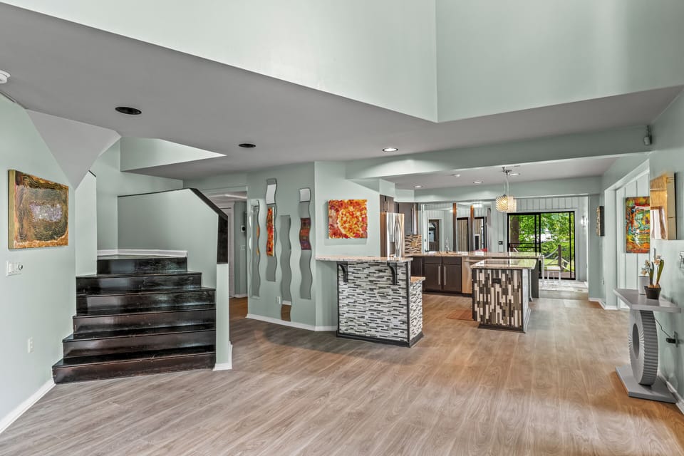 Expansive open-concept living area with colorful accents, modern shelving, and seamless flow into the kitchen.