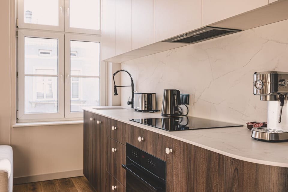 Modern kitchen with large windows and elegant finishes – cook with a city view.