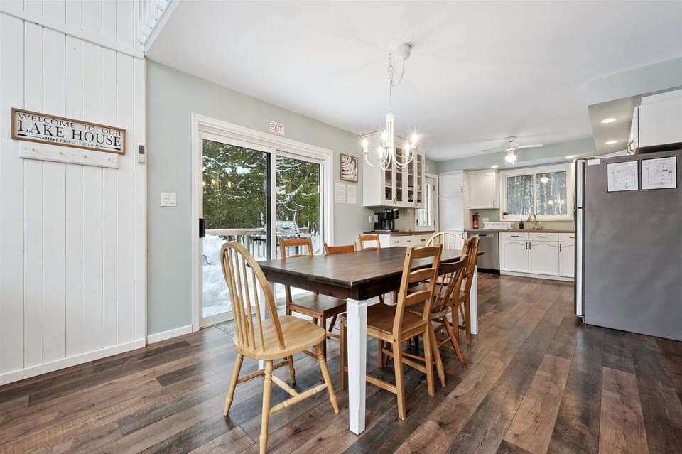 Open-concept dining area with large table, sliding doors, and easy kitchen access